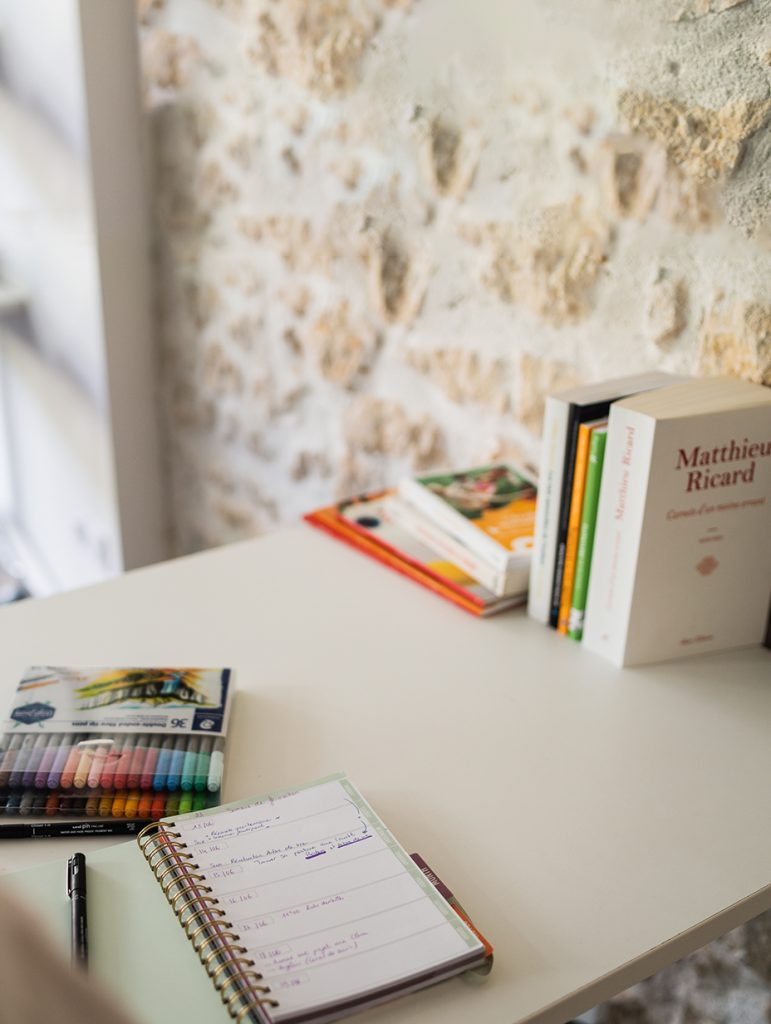 Pile de livres sur le business et le développement, à côté d'un cahier et de stylos