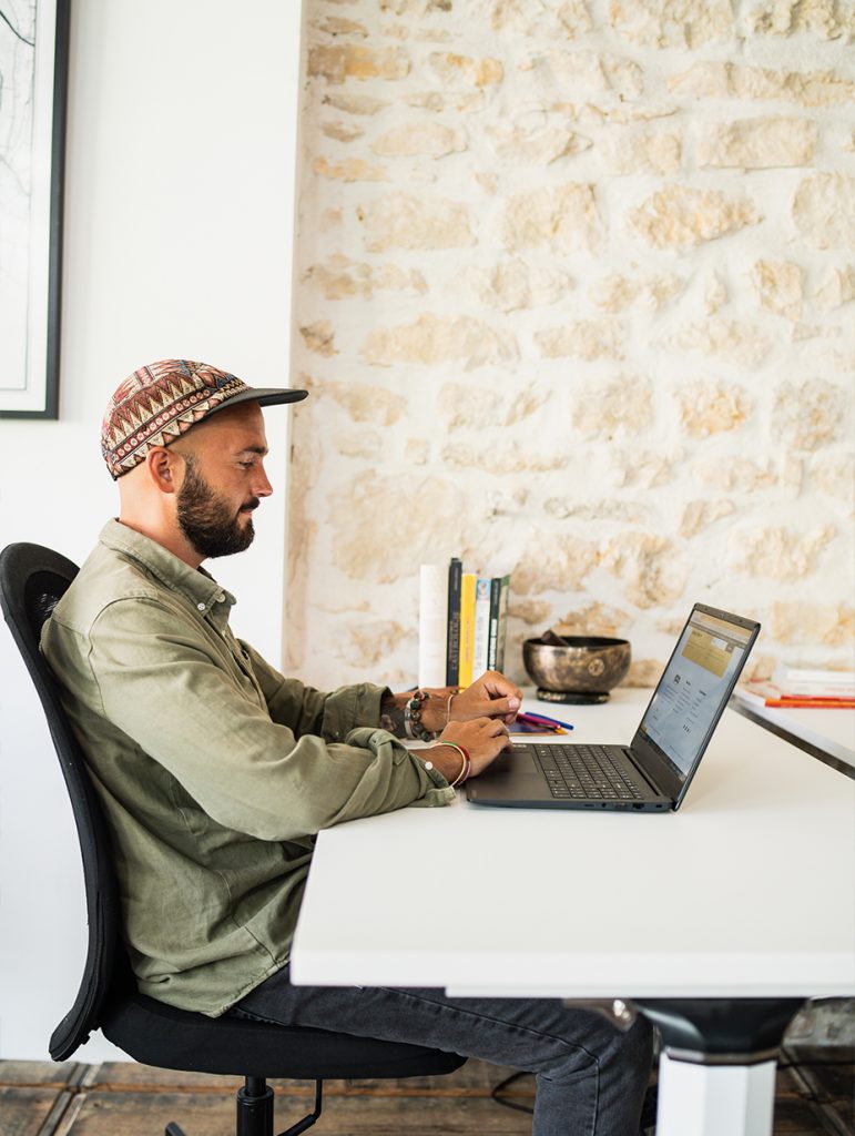 Emeric SIMON travaillant sur un ordinateur dans un bureau moderne